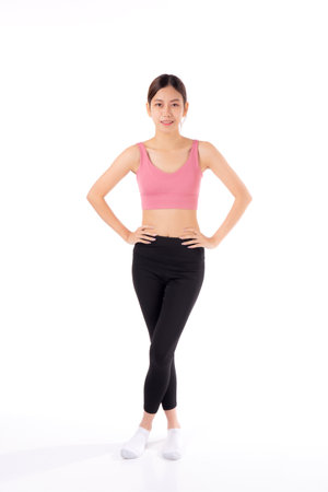 Portrait of beautiful young woman in sportwear smile and showing waist and abs isolated on white background, sport and exercise for health, female slimming with confident and wellnessの写真素材