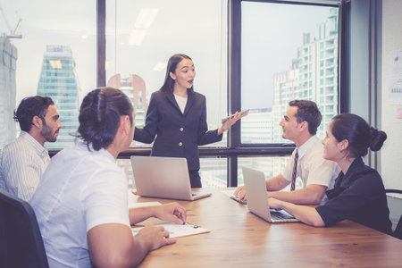 Group business people team meeting together while woman presenting and explaining about planning and strategy marketing in modern office, brainstorming and collaboration of teamwork, business concept.の写真素材