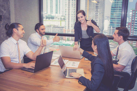 Group business people team meeting together while woman presenting and explaining about planning and strategy marketing in modern office, brainstorming and collaboration of teamwork, business concept.の写真素材