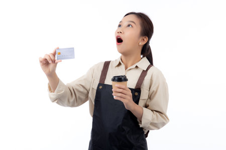Portrait happiness young asian woman wearing apron holding credit card while shock with surprise isolated white background, barista or waitress showing debit card for purchase online, small business.の写真素材