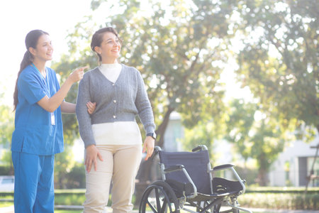 Young caucasian nurse comforting with patient while standing in outdoor park, doctor woman support and counseling with patient, caregiver and service with senior, medical and consoling.の写真素材
