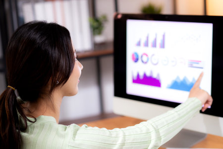 Young asian businesswoman planning and strategy about finance looking graph and chart of report marketing in home office, business woman analyzing financial and revenue for success, business concept.の写真素材