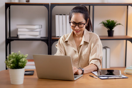 Happiness young businesswoman using laptop computer on desk in living room at home office, business woman using laptop for surfing internet, entrepreneur or freelance, business and communication.の写真素材