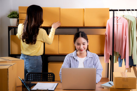 Two young asian businesswoman checking order of customer for laptop computer and document, shipment and cargo, retail with online seller and store, startup or small business, shipping and inventory.の写真素材