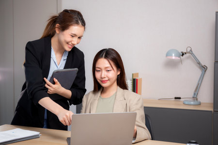 Two young business woman working together about project for success in modern office, businesswoman discussion with consulting for planning and analyzing about marketing, business and strategy.の写真素材