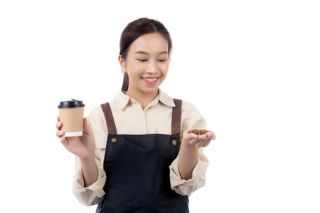 Portrait young asian barista woman wearing apron holding beans coffee and coffee cup isolated white background, waitress or entrepreneur cheerful, small business or startup, waiter of cafe.の写真素材