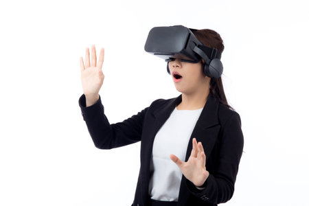 Portrait young asian businesswoman wearing headset virtual reality for device with experience and entertainment with interactive isolated white background, simulation and innovation with business.の写真素材