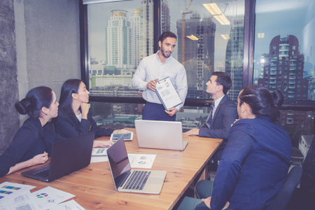 Group business people team meeting together while man presenting and explaining about planning and strategy marketing in modern office, brainstorming and collaboration of teamwork, business concept.の写真素材