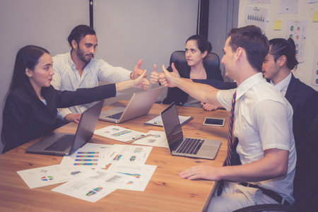 Group business team collaboration while thumbs up with success together in office, business teamwork and motivation for achievement of working, business and colleagues with harmony.の写真素材