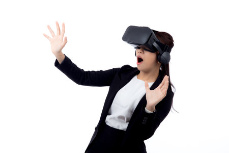 Portrait young asian businesswoman wearing headset virtual reality for device with experience and entertainment with interactive isolated white background, simulation and innovation with business.の写真素材