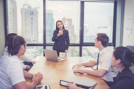 Group business people team meeting together while woman presenting and explaining about planning and strategy marketing in modern office, brainstorming and collaboration of teamwork, business concept.の写真素材