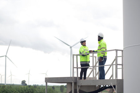 Two young engineer handshake about agreement of success renewable in wind turbines farm, renewable energy and sustainable collaboration for success and innovation, engineer shaking hands.の写真素材