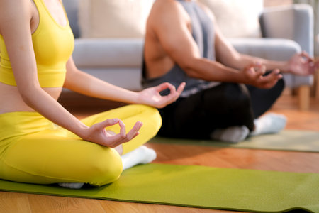 Closeup hands couple practicing yoga and meditation together in the living room at home, relaxation, wellness and healthy lifestyle, calm and enjoying mindful tranquility with yoga, sport for health.の写真素材