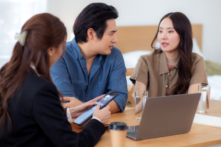 Happy asian couple discussion with real estate agent or insurance agent for investment in home office, mortgage loan or property purchase home, sale explaining insurance plan with couple.の写真素材