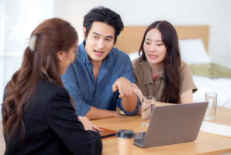 Happy asian couple discussion with real estate agent or insurance agent for investment in home office, mortgage loan or property purchase home, sale explaining insurance plan with couple.の写真素材