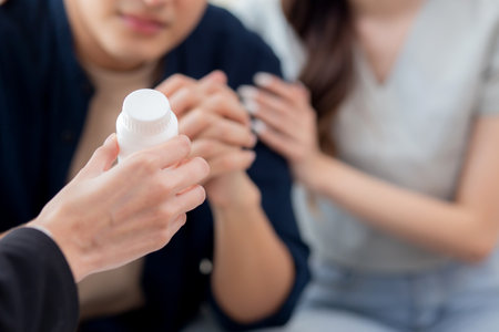 Closeup hands of therapist counseling with asian couple counseling for support and guidance about depression with stress and worry, psychiatrist healing couple with problem mental health.の写真素材