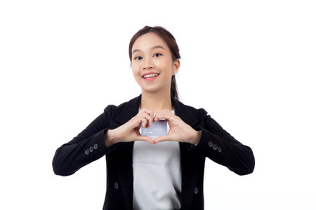 Portrait young asian businesswoman holding credit card or debit card smiling with confident isolated white background, business woman holding credit card for shopping, transaction and financial.の写真素材