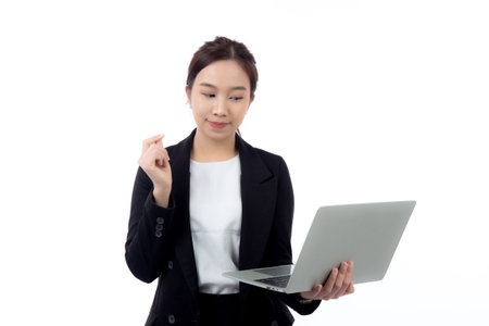 Portrait young asian business woman standing work on laptop computer thoughtful isolated on white background, businesswoman in suit thinking idea using notebook, marketing and communication.の写真素材