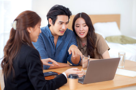 Happy asian couple discussion with real estate agent or insurance agent for investment in home office, mortgage loan or property purchase home, sale explaining insurance plan with couple.の写真素材