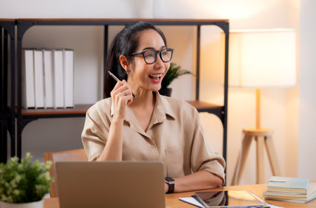 Young asian business woman using laptop for success in modern home office, businesswoman working with laptop computer gesture glad in living room at home, business and freelance concept.の写真素材