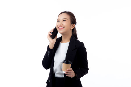 Portrait cheerful young asian businesswoman holding coffee cup while talking smart phone with relax and satisfied isolated white background, business woman drinking coffee and speaking on smartphone.の写真素材