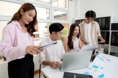 Young asian business team collaboration on project in modern office, group business people working brainstorming for planning and strategy of marketing and finance, teamwork of startup.の写真素材