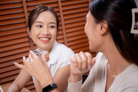 Two asian businesswoman testing and researching cosmetic product or cream in bottle in office, two business woman creative with planning project design package of skincare, development and business.の写真素材