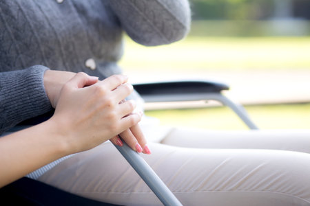 Closeup hand young nurse comfort with patient while sitting on wheelchair in outdoor park, doctor woman support and counseling with patient, caregiver and service, medical and consoling.の写真素材