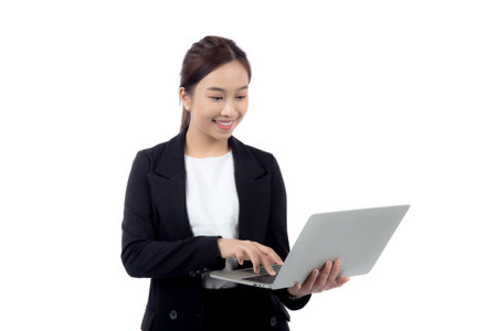 Portrait young asian business woman standing work on laptop computer to internet online isolated on white background, businesswoman in suit confident and using notebook, marketing and communication.の写真素材