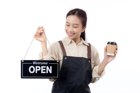 Portrait young asian barista woman wearing apron holding open sign and coffee cup for inviting customer to enter with happiness, waitress woman holding signboard, small business or startup business.の写真素材