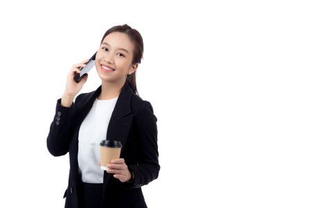 Portrait cheerful young asian businesswoman holding coffee cup while talking smart phone with relax and satisfied isolated white background, business woman drinking coffee and speaking on smartphone.の写真素材