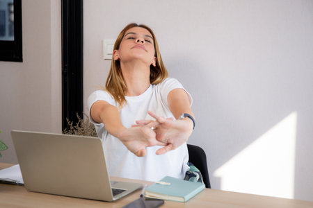 Portrait young caucasian businesswoman taking a break after overworked with stretching arm and hand in living room at home office, business woman relax with ergonomic, business and health.の写真素材