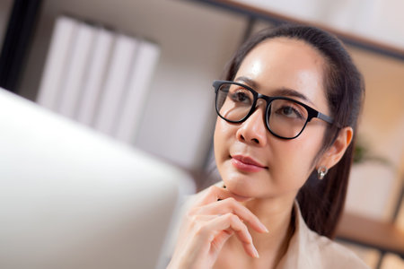 Young asian business woman working with desktop computer while thinking for planning financial on desk in modern home office, businesswoman planning and thoughtful about working, business and finance.の写真素材
