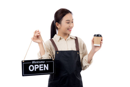 Portrait young asian barista woman wearing apron holding open sign and coffee cup for inviting customer to enter with happiness, waitress woman holding signboard, small business or startup business.の写真素材