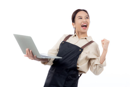 Portrait young asian business woman wearing apron holding laptop computer isolated white background, waitress or barista holding laptop computer with success, cut out, business or freelance.の写真素材