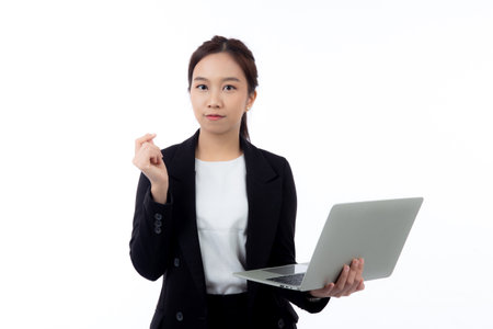 Portrait young asian business woman standing work on laptop computer thoughtful isolated on white background, businesswoman in suit thinking idea using notebook, marketing and communication.の写真素材