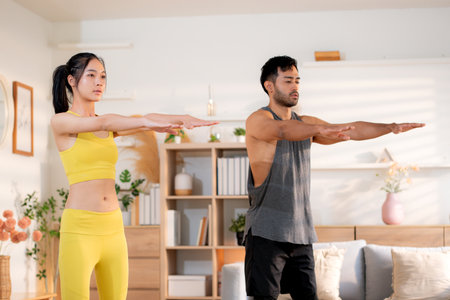 Fitness coach guidance with asian woman during squat training at home in living room, workout and...