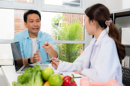 Asian nutritionist consulting patient in clinic, meal plan discussion, healthcare advice, weight loss support, doctor talking and explaining patient for nutrition consultation, wellness care.の写真素材