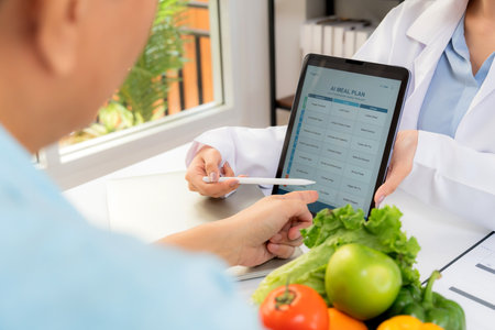 Asian nutritionist using tablet to explaining personalized meal plan with AI to patient during healthcare consultation, healthy lifestyle, woman dietitian showing nutrition plan with AI on tablet.の写真素材