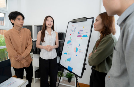 Group asian business team meeting together in office, colleagues discuss report marketing, data analysis, project planning, brainstorming and strategy planning, team conference about marketing.の写真素材