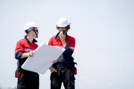 Two engineer checking solar energy system looking blueprint for planning installation solar panel...