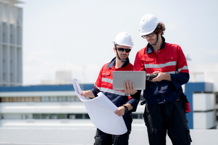 Two engineer checking solar energy system looking blueprint together for planning installation solar panel, renewable energy and sustainable technology, clean electricity, industry and solar cell.の写真素材