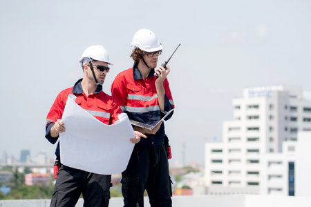 Two engineer checking solar energy system looking blueprint for planning installation solar panel...