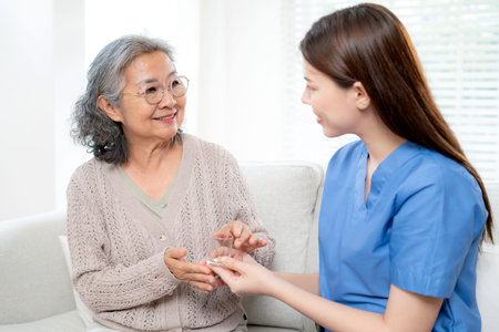 Asian woman nurse or doctor giving medicine for senior patient, caregiver giving drug or pill to...
