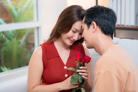 Happy asian woman receiving rose bouquet from boyfriend with celebrating Valentine's Day or...
