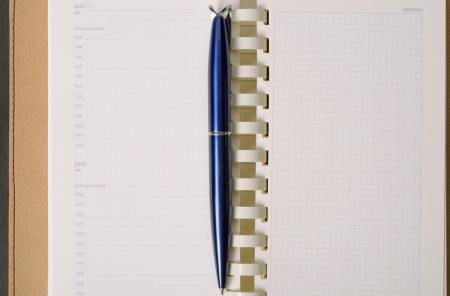 Open notebook with pen on clean sheetsの写真素材