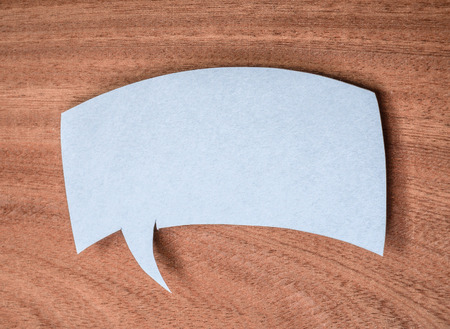 The paper speech bubble on a wooden background