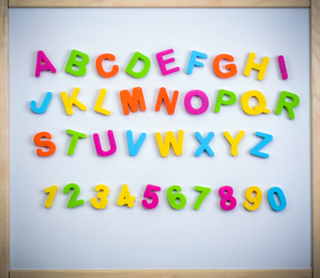 English alphabet made of plastic letters and numbers on a magnetic boardの写真素材