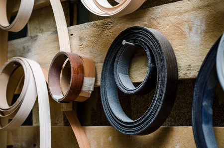 Ribbon trim chipboard on a wooden bench, furniture repair. close-up backgroundの写真素材