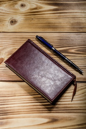 Diary and pen on the wooden background. Close-upの写真素材